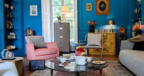 a blue living room with two chairs and a table at CHATEAU DE BRINVILLE in Saint-Sauveur-sur-École