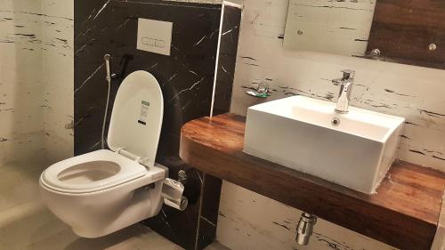 a bathroom with a white toilet and a sink at Hotel Delhi Aerocity in New Delhi