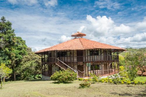 a large hut with a thatched roof in a field at San Agustin Internacional Hotel in San Agustín