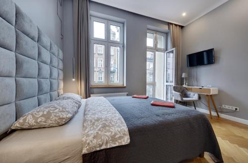 a bedroom with a large bed with a large headboard at Dodo Acomodo 5 in Katowice