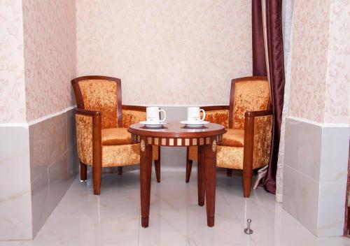 a table with two chairs and a table with two cups on it at Easy Hotel Kenya in Nairobi