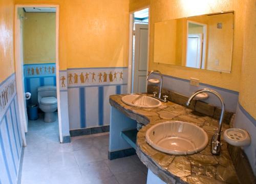 a bathroom with two sinks and a large mirror at San Agustin Internacional Hotel in San Agustín