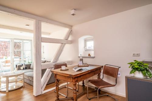 Habitación con escritorio, sillas y sala de estar. en chez Douverne Hotel mit Hästens Betten, en Sommerach