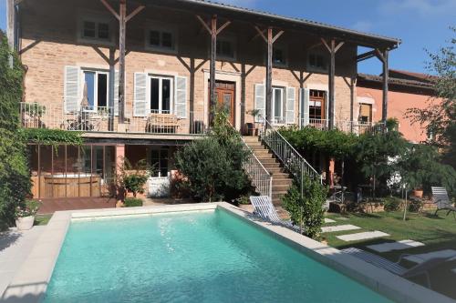 a house with a swimming pool in front of a house at La petite madeleine - Chambre d'hôtes & spa in Burgy