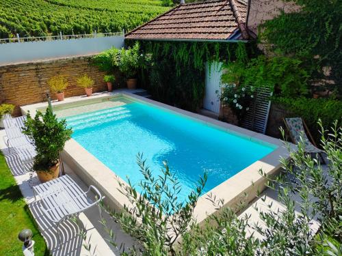 - une vue sur la piscine et ses 2 chaises blanches dans l'établissement La petite madeleine - Chambre d'hôtes & spa, à Burgy