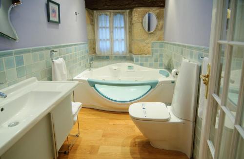 a bathroom with a toilet and a sink and a tub at Casa Rómulo in Duruelo de la Sierra