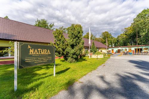 a sign in the grass in front of a building at Natura Ferienpark - Bungalows am Grimnitzsee Schorfheide in Althüttendorf