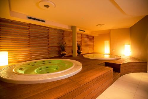 a bathroom with two tubs in the middle of it at Hotel Chrys in Bolzano