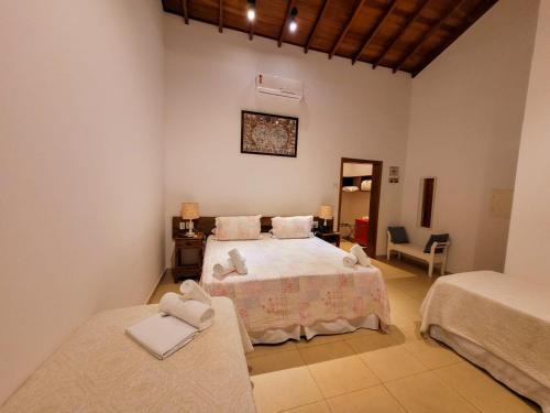 1 dormitorio con 1 cama y 1 silla en Pousada Fazenda Peroba Rosa, en Pedregulho