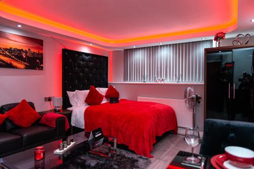 a red bedroom with a bed and a couch at Meridian Serviced Apartments in Bradford