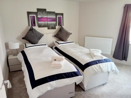 a bedroom with two beds and a mirror on the wall at Glorious Duplex Holiday Apartment By The Sea in Bognor Regis