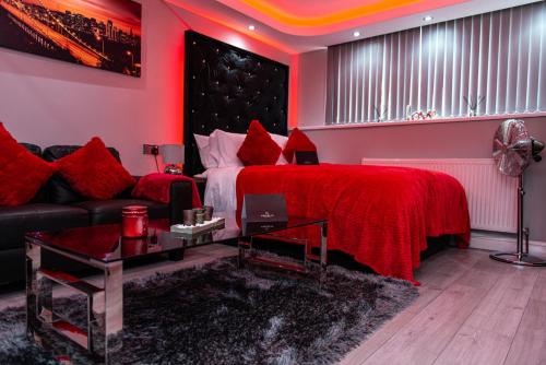 a red bedroom with a bed and a couch at Meridian Serviced Apartments in Bradford