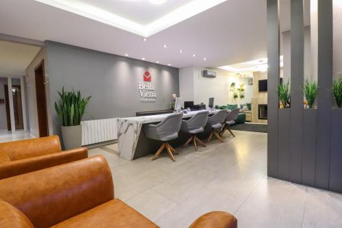 een lobby met stoelen en een lange tafel in een gebouw bij Pousada Bella Viena in Gramado