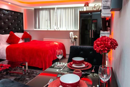 a room with a table and a bed and a red room at Meridian Serviced Apartments in Bradford