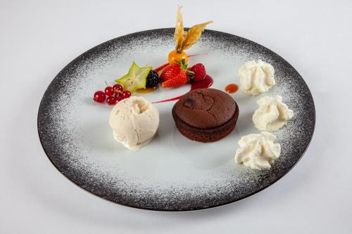 a plate of food with a chocolate dessert and fruit at Hotel Restaurant Laborderie in Tamniès