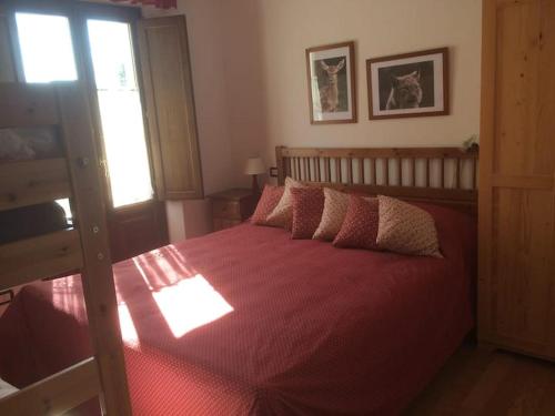 een slaapkamer met een groot bed en een rode deken bij Casa Val di Rose in Civitella Alfedena