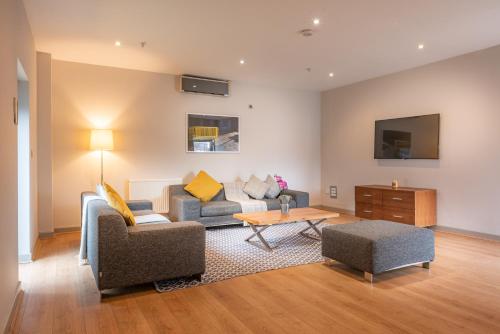 a living room with a couch and a table at PREMIER SUITES PLUS Glasgow George Square in Glasgow