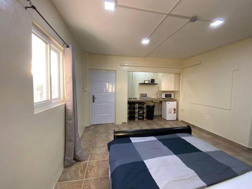 een slaapkamer met een bed in een kamer met een raam bij Cozy Studio Apartment Minutes from the Beach in Willemstad