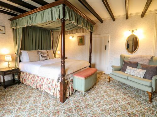 a bedroom with a canopy bed and a couch at The Farmhouse in Bakewell