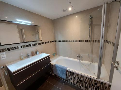 een badkamer met een bad, een wastafel en een douche bij Primeurs appartement haut standing de 85 m², Luxembourg-Kirchberg in Luxemburg