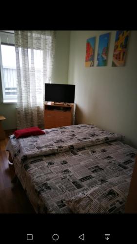 Schlafzimmer mit einem Bett, einem Schreibtisch und einem TV in der Unterkunft Мост Сити in Dnipro