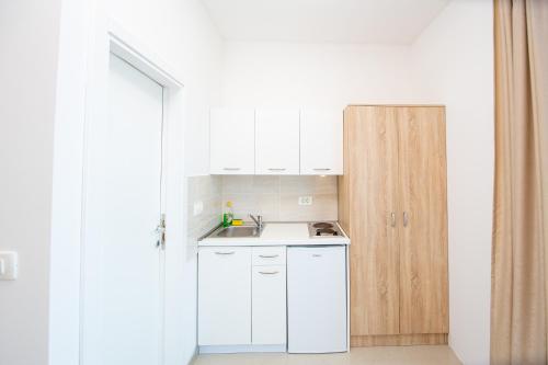 a small kitchen with white cabinets and a sink at Apartment Sofija in Budva