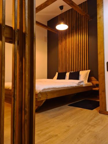 a bedroom with a bed with a wooden wall at Colfly Studios in Braşov