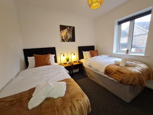 ein Schlafzimmer mit zwei Betten und einem Fenster in der Unterkunft 3 Bed House with Garage, NR BPW & Brecon Beacons National Park in Cefn-coed-y-cymmer