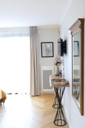 Cette chambre comprend un miroir et une table. dans l'établissement Les Agapanthes, à Camphin-en-Pévèle