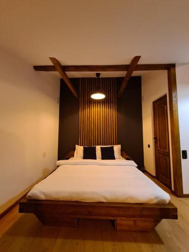 a bedroom with a large bed with a wooden headboard at Colfly Studios in Braşov