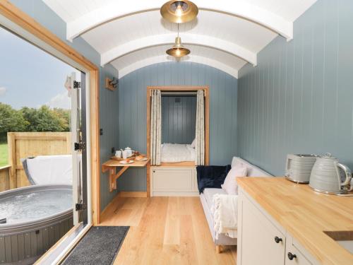 a bathroom with a bath tub and a window at Honeysuckle Hut, Myrtle Farm in Bristol