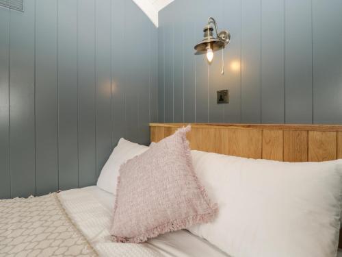 sypialnia z łóżkiem z różową poduszką w obiekcie Honeysuckle Hut, Myrtle Farm w Bristolu