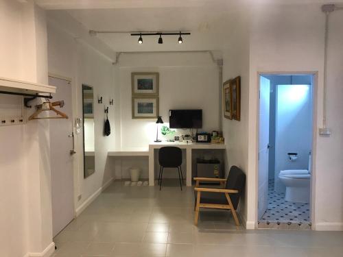 a bathroom with a desk and a toilet in a room at Baan Suandao Wat Arun in Bangkok