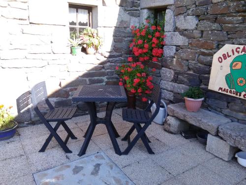 a table and two chairs next to a wall with flowers at Four chimneys in Treffrin