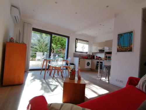 ein Wohnzimmer mit einem roten Sofa und einem Tisch in der Unterkunft Lou Farniente - Les Lecques - Fabuleux in Saint-Cyr-sur-Mer