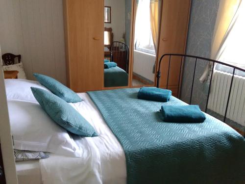 a bedroom with a bed with pillows and a mirror at Four chimneys in Treffrin