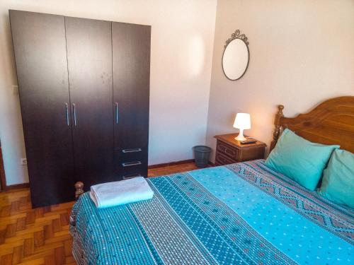 um quarto com uma cama e um armário grande em Enjoy Braga Estação - Charming Bedrooms in the Historic Center em Braga