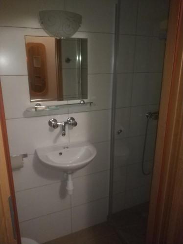 a bathroom with a sink and a shower with a mirror at Hotel Mark in Marki