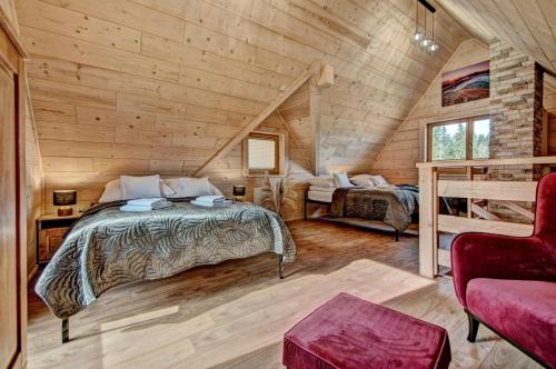 a bedroom with a bed in a log cabin at Jędroskowe Chatki in Witów