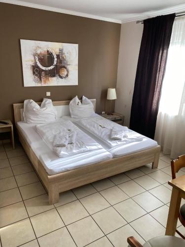 a bedroom with a large bed with white sheets at Gaststätte Pütz in Siegen