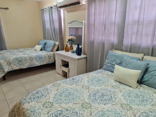a bedroom with two beds and a table with a mirror at Sandpiper Beach Apartments in Palm-Eagle Beach