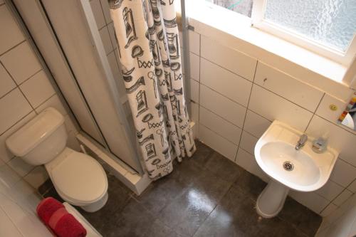 a bathroom with a toilet a sink and a bath tub at Hostal Po in Valparaíso