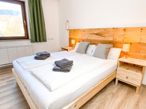 a bedroom with a large white bed with a wooden headboard at Haus Traun-Ufer in Bad Ischl