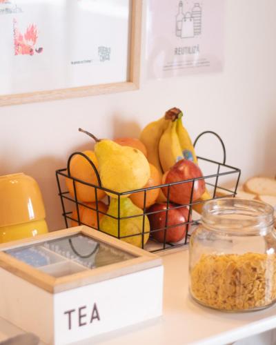Chepatagonia Hostel & Experiences في بويرتو مادرين: سلة فاكهة على المنضدة مع جرة شاي