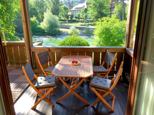 a table and chairs on a porch with a view of a river at Haus Traun-Ufer in Bad Ischl