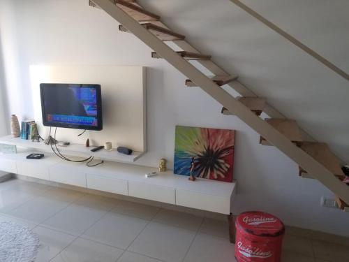 een woonkamer met een televisie op een witte plank bij Departamento moderno con cochera en lomas de Zamora in Lomas de Zamora