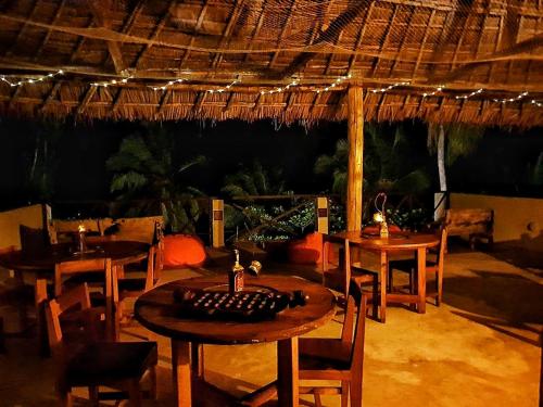 a restaurant with wooden tables and chairs and lights at Ayla Beach House in Kiwengwa