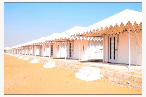 a row of white tents on a beach at Jaisalmer Desert Resort in Jaisalmer