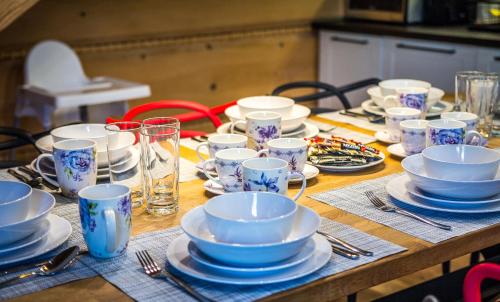 a wooden table topped with blue and white cups and plates at Etiuda Zakopane in Zakopane