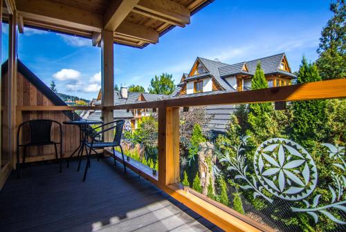 a deck with a view of a house at Etiuda Zakopane in Zakopane